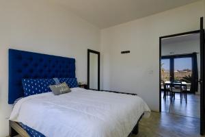 a bedroom with a large bed with a blue headboard at Las Palmas Hotel - Cerritos Beach in El Pescadero +54 photos