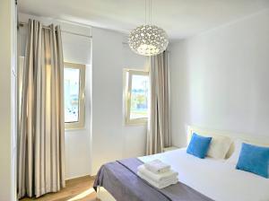 a bedroom with a bed with blue pillows and a chandelier at Sunny Beach Apartments - 147 in Durrës