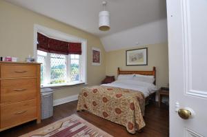 a bedroom with a bed and a dresser and a window at Hollins Lodge in Grosmont +2 photos