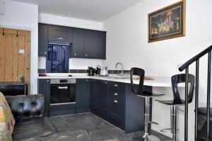 a kitchen with dark blue cabinets and a counter at Hollins Lodge in Grosmont