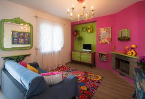 a living room with a blue couch and pink walls at In ta Villa da u Perinetti in Bastia