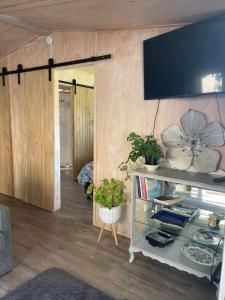 a living room with a tv on the wall at Hideaway Haven in Raglan