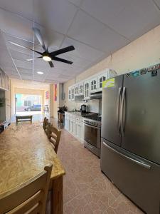a kitchen with a stainless steel refrigerator and a table at Hostal Charlotte in La Unión