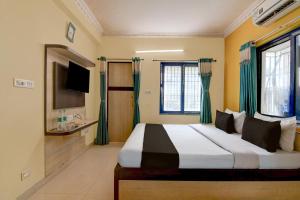 a bedroom with a large bed with green curtains at Hotel O Shyam sundar Hotel in kolkata