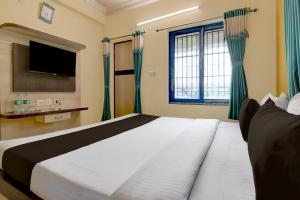 a bedroom with a large bed and a television at Hotel O Shyam sundar Hotel in kolkata
