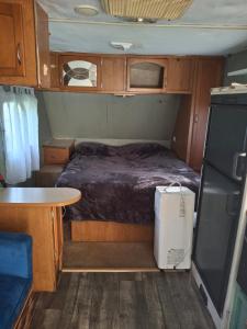 a small bedroom in an rv with a bed and a table at Private Cozy Camper in Burnside