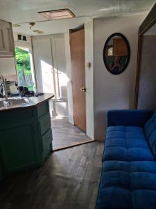 a living room with a blue couch and a sink at Private Cozy Camper in Burnside