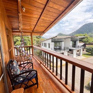 a porch with chairs and a view of a house at Hostal Vista Verde in Mindo