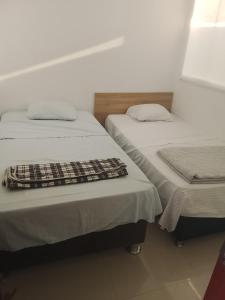 two beds sitting next to each other in a room at casa completa huanchaco con estacionamiento EL REFUGIO SECRETO in Huanchaco