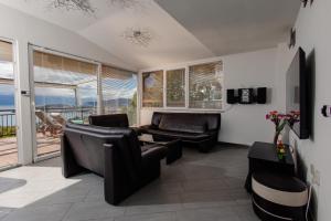 a living room with leather furniture and a balcony at Villa Aurora in Ohrid
