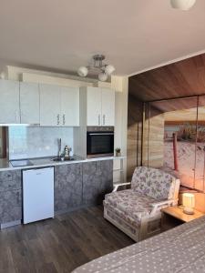 a living room with a couch and a kitchen at Infinity Sea View Studio in Pomorie