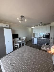 a bedroom with a large bed and a kitchen at Infinity Sea View Studio in Pomorie +5 photos