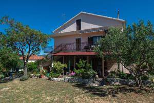a large house with a balcony and trees at Apartments Saric in Jadrtovac