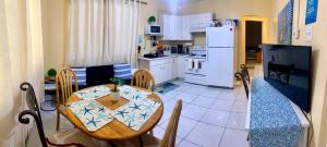 a kitchen and dining room with a table and a refrigerator at SUITE 1, BLUE PAVILION - Steps to BEACH - NEW AC in West Bay