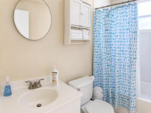 a bathroom with a toilet and a sink and a mirror at SUITE 1, BLUE PAVILION - Steps to BEACH - NEW AC in West Bay