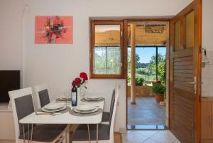a dining room with a white table and chairs at Apartments Saric in Jadrtovac