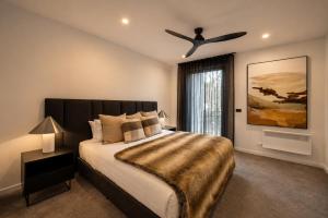 a bedroom with a large bed with a ceiling fan at Black Sheep alpine getaways in Dinner Plain