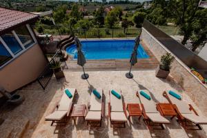 an overhead view of a pool with lounge chairs and a swimming pool at Villa Aurora in Ohrid