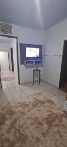 a living room with a flat screen tv on the wall at Recanto do Vô Dito e pet friendly in Camanducaia