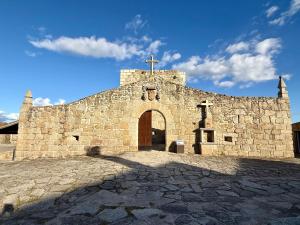 an old stone church with a cross on the front at Casa D Dinis in Alfaiates
