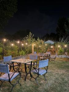 a group of picnic tables and chairs at night at Vila Zyle in Velipojë