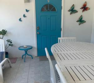 a blue door in a room with butterflies on the wall at SUITE 1, BLUE PAVILION - Steps to BEACH - NEW AC in West Bay
