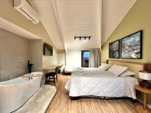a bedroom with a large bed and a bath tub at Luna Hotel Boutique - Frente à Praia in Guarujá +110 photos
