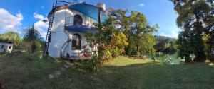 a house in the grass next to a body of water at tamasopo y sus rios in Tambaca