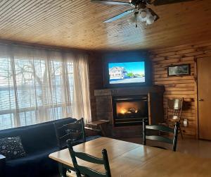 a living room with a table and a fireplace at Sandy Shore Cottages Luxury Resort on Rice Lake in Harwood