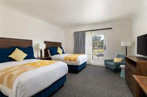 a hotel room with two beds and a flat screen tv at La Playa Inn Santa Barbara in Santa Barbara +134 photos