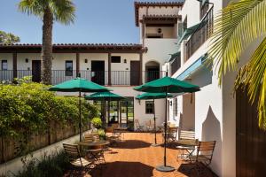 a patio with tables and chairs with umbrellas at La Playa Inn Santa Barbara in Santa Barbara