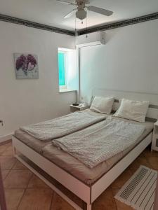 a bedroom with a large bed with a ceiling fan at The Grimme Residence in Xiropigado