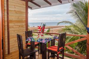 una mesa y sillas en un porche con la playa en Pirate Cove, en Drake
