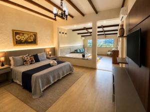 a bedroom with a bed and a bathroom with a tub at Pousada Santa Fe de Penedo in Penedo