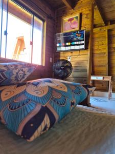 a bedroom with a bed in a log cabin at Chalés Ilha da Mata Pousada in Florianópolis +66 photos