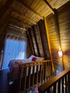 an attic room with a bed and a window at Chalés Ilha da Mata Pousada in Florianópolis