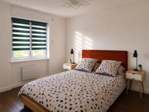 a bedroom with a large bed with two windows at Cosy Normandy - Bloom in Sourdeval