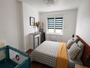 a bedroom with a bed and a window at Cosy Normandy - Bloom in Sourdeval