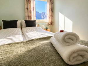 a bedroom with a bed with towels on it at KB - Waterfront Villa Sørvågen in Moskenes