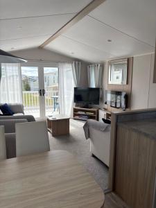 a living room with a couch and a television at Dune View Caravan in Lossiemouth