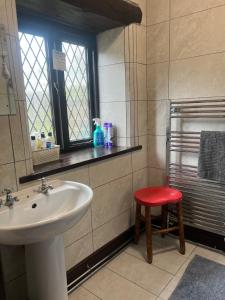 a bathroom with a sink and a red stool at The Old Mill and Cottage in Matlock +39 photos