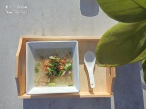 un tazón de sopa con una cuchara en una caja de madera en Ban Roojai, en Nan