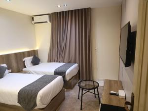 a hotel room with two beds and a television at Tamaya Hotel, Fifth Settlement, New Cairo in Cairo