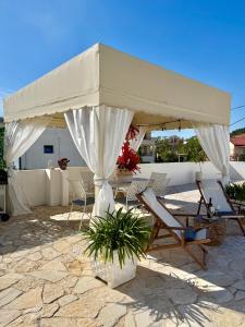 a table and chairs under a white umbrella at Mediterranean Villa Old Town in Vlorë