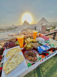 a table with food and drinks on a table with pyramids at Dima Plaza Pyramids View in Cairo