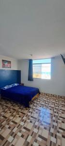a bedroom with a blue bed and a checkered floor at Hotel MIRALMAR in El Puente +19 photos