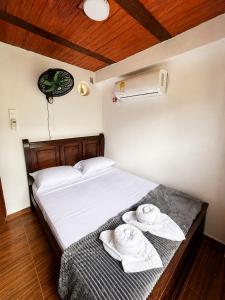 a bedroom with a bed with towels on it at Hostal Nomadax Tayrona in El Zaino