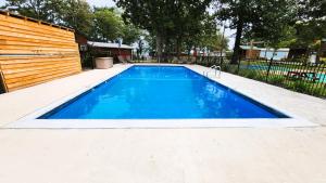 a swimming pool in a backyard with a wooden fence at Lee's Grand Lake Resort Cabin 4 in Grove