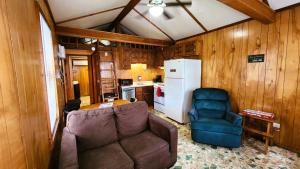a living room with a couch and a kitchen at Lee's Grand Lake Resort Cabin 4 in Grove