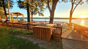 a wooden deck with tables and a gazebo on the water at Lee's Grand Lake Resort Cabin 4 in Grove